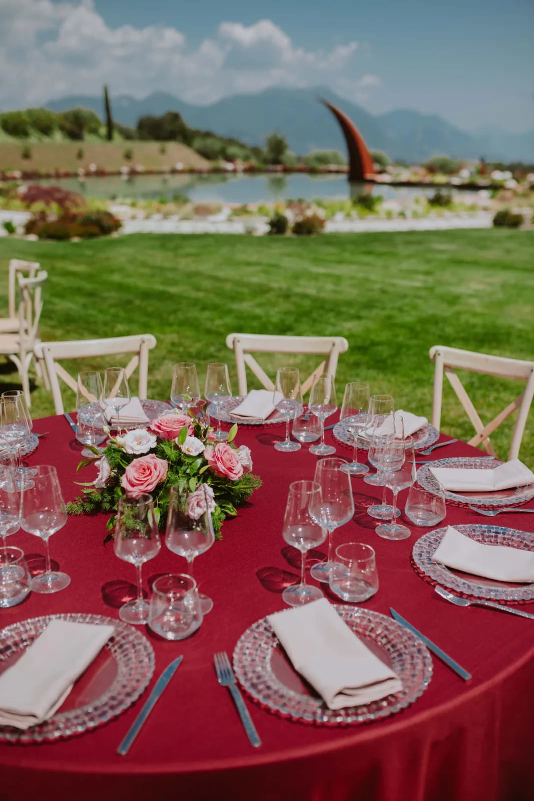 Ein Tisch mit Rosen und Gläsern auf der Wiese